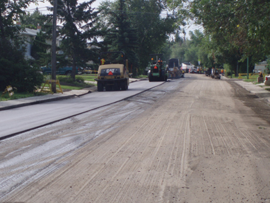 Asphalt rollers compact the newly asphalted side of Dorothy Street, beside a milled section along the same road