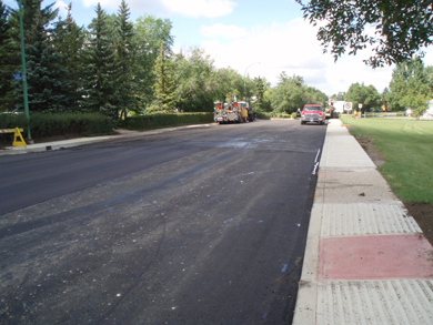 La surface fraîchement asphaltée et nivelée de la rue Dorothy avec ses nouvelles bordures et trottoirs des deux côtés