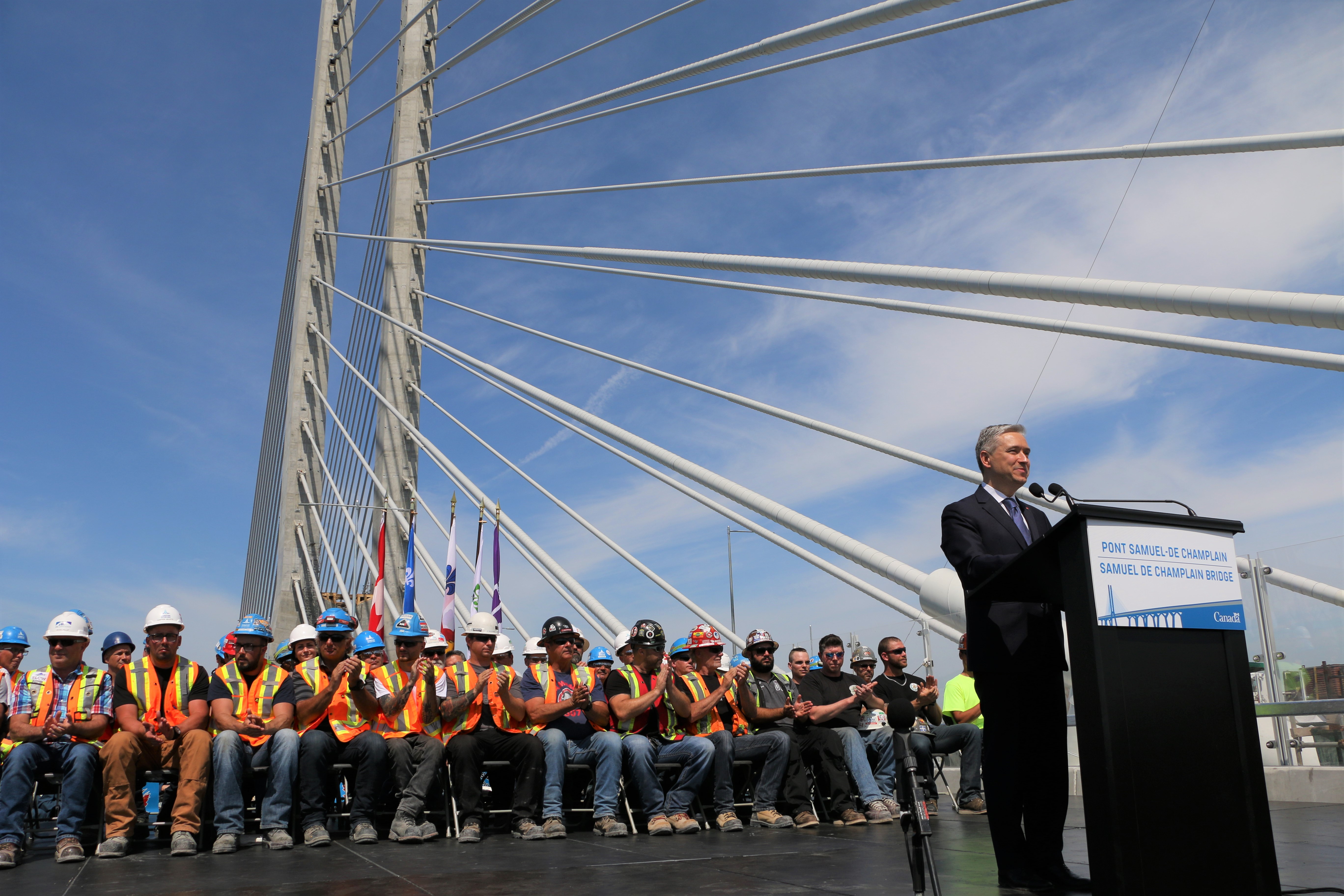 Le ministre François-Philippe Champagne avec des travailleurs qui ont participé à la construction du pont Samuel-De Champlain.  