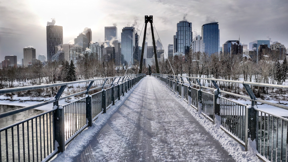 Snow covered footbridge amidst buildings (Calgary, Alberta)